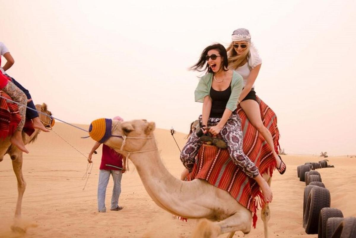 two women riding on a camel in the desert
