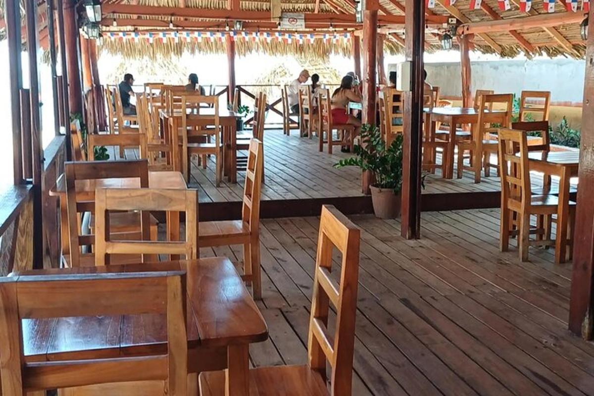 a restaurant with wooden tables and chairs on a deck