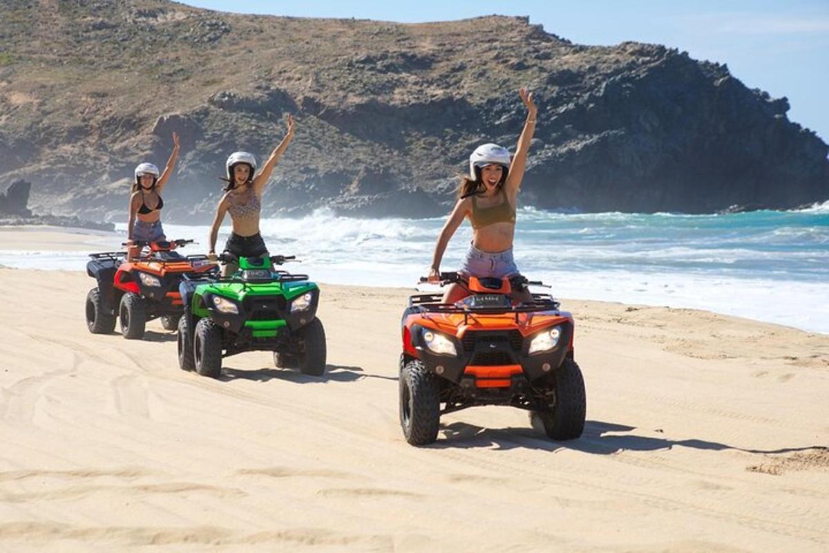 tres noies muntant quads a la platja