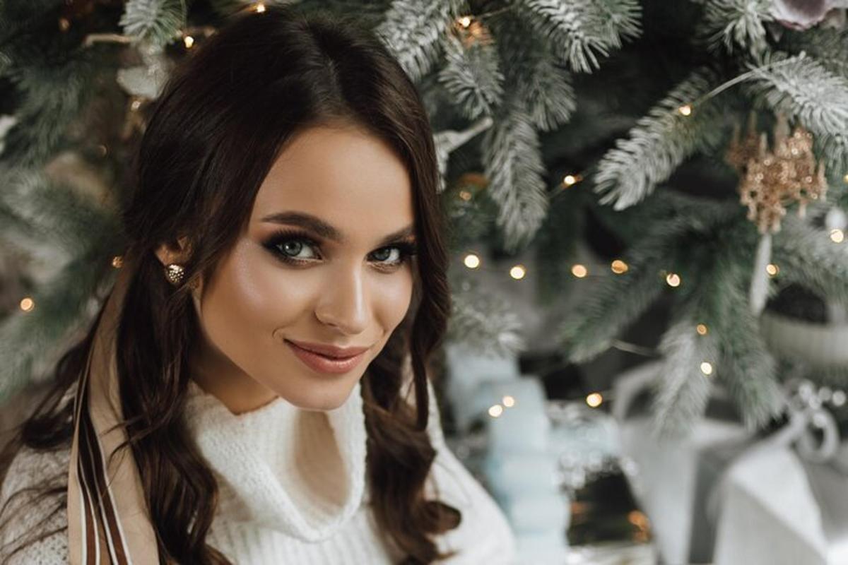 una donna in piedi davanti a un albero di Natale