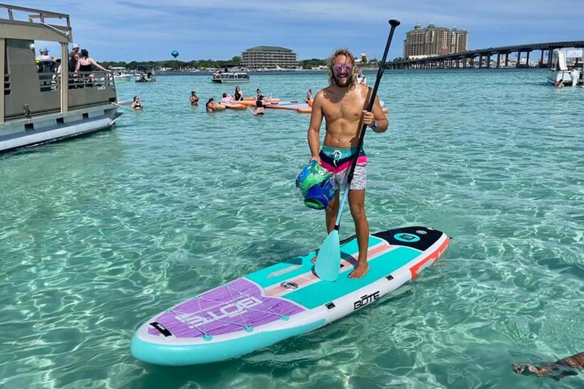 un home dret sobre una taula de paddle surf a l'aigua