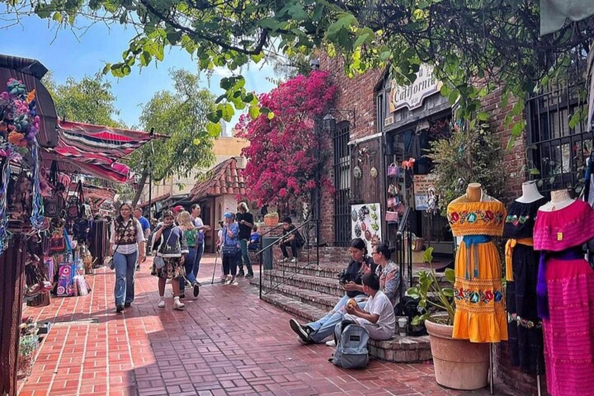 a group of people sitting on a sidewalk in a street