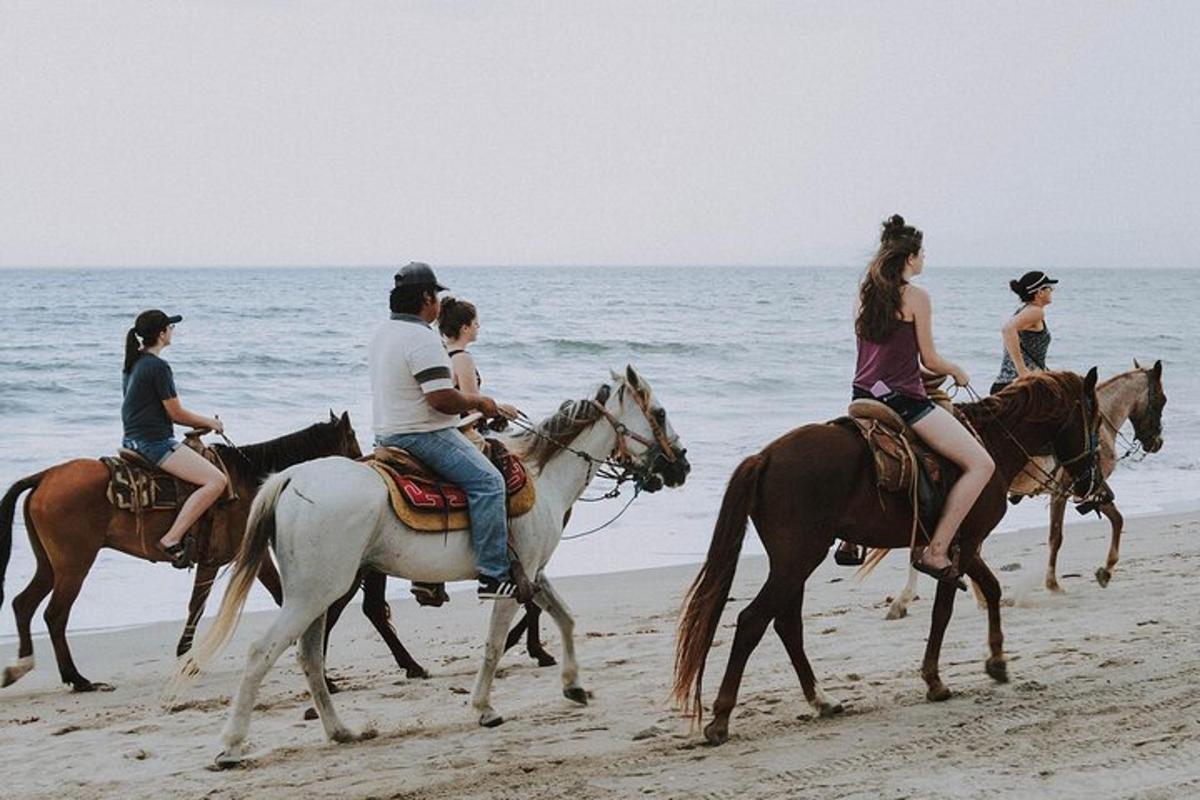 eine Gruppe von Menschen reitet am Strand