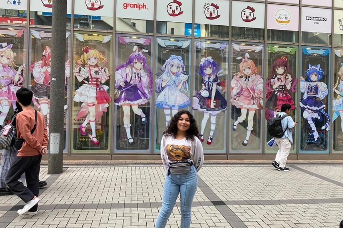 žena stojící před budovou s anime panely