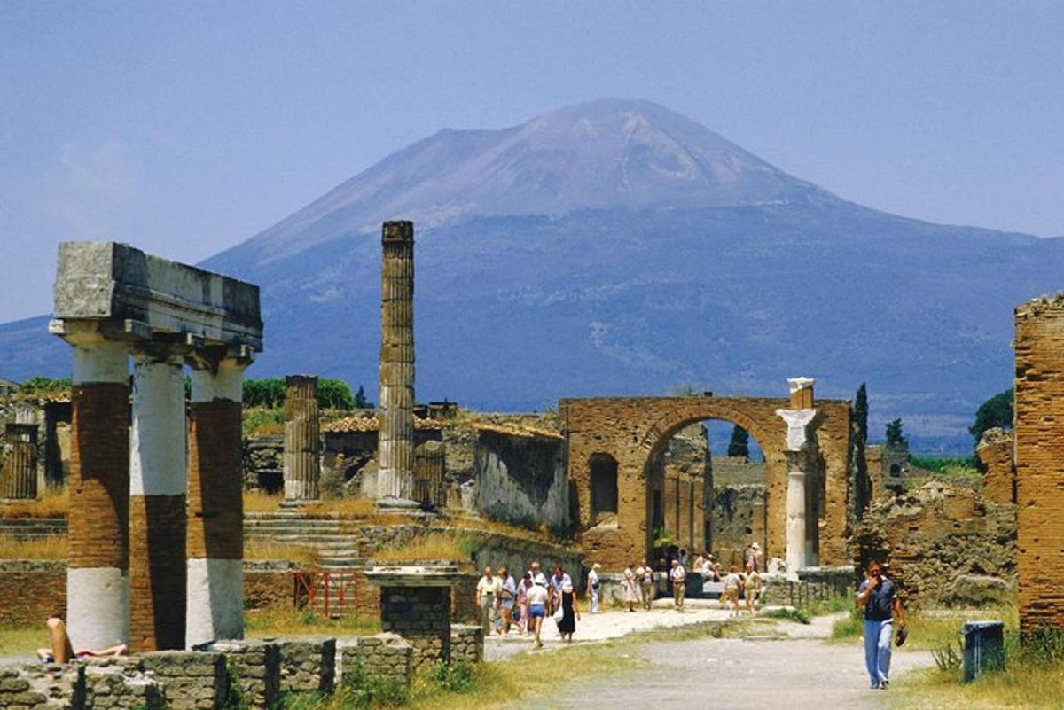 una montagna in lontananza con un gruppo di persone in antiche rovine