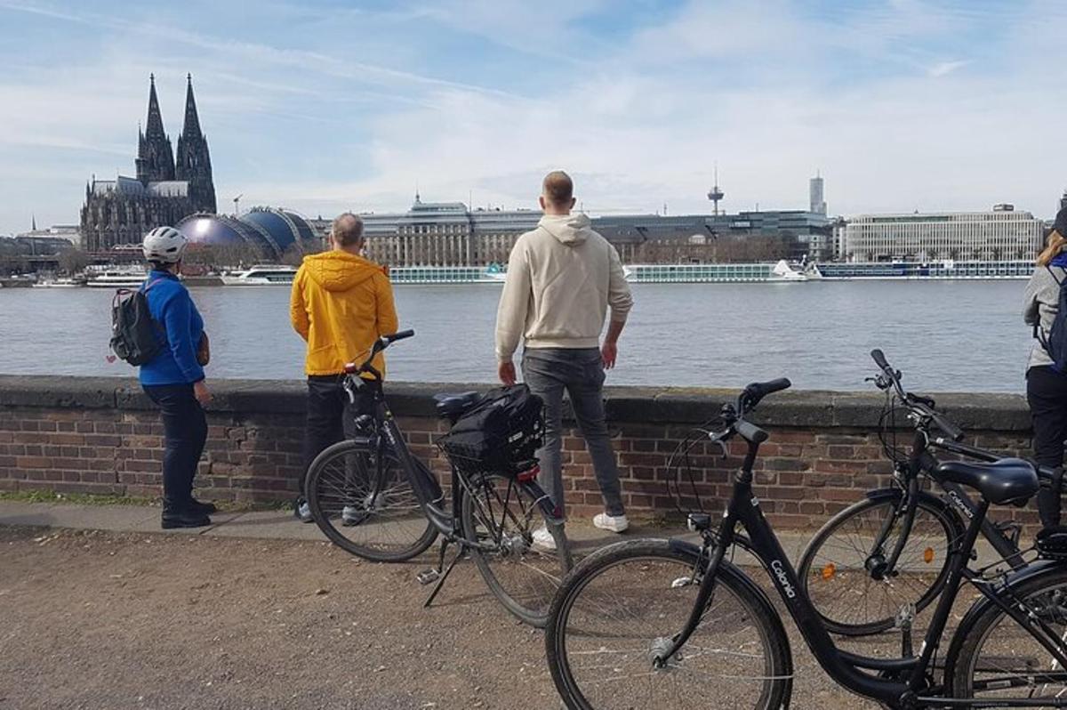 hópur fólks stendur á vegg með hjól