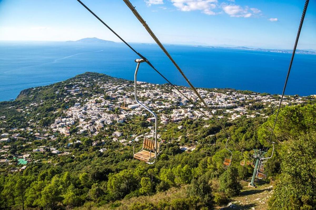 μια γόνδολα που πετάει πάνω από μια πόλη σε ένα βουνό
