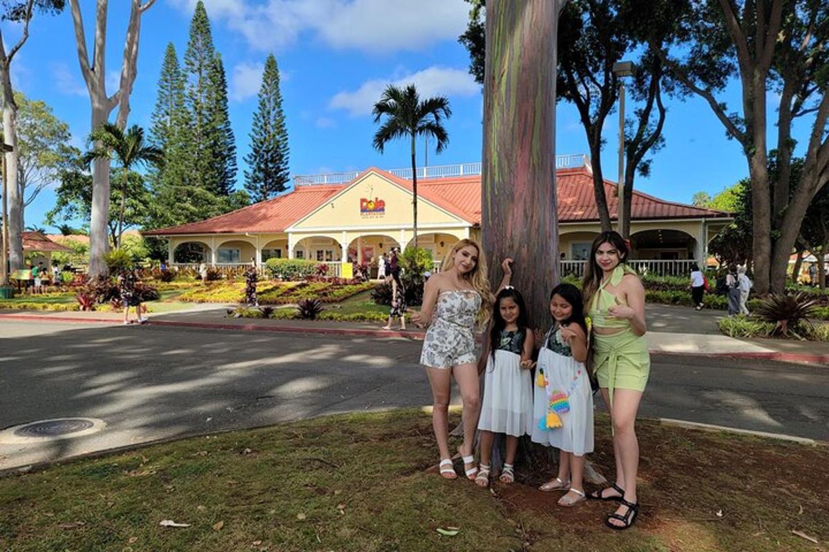 a group of women and children standing next to a tree
