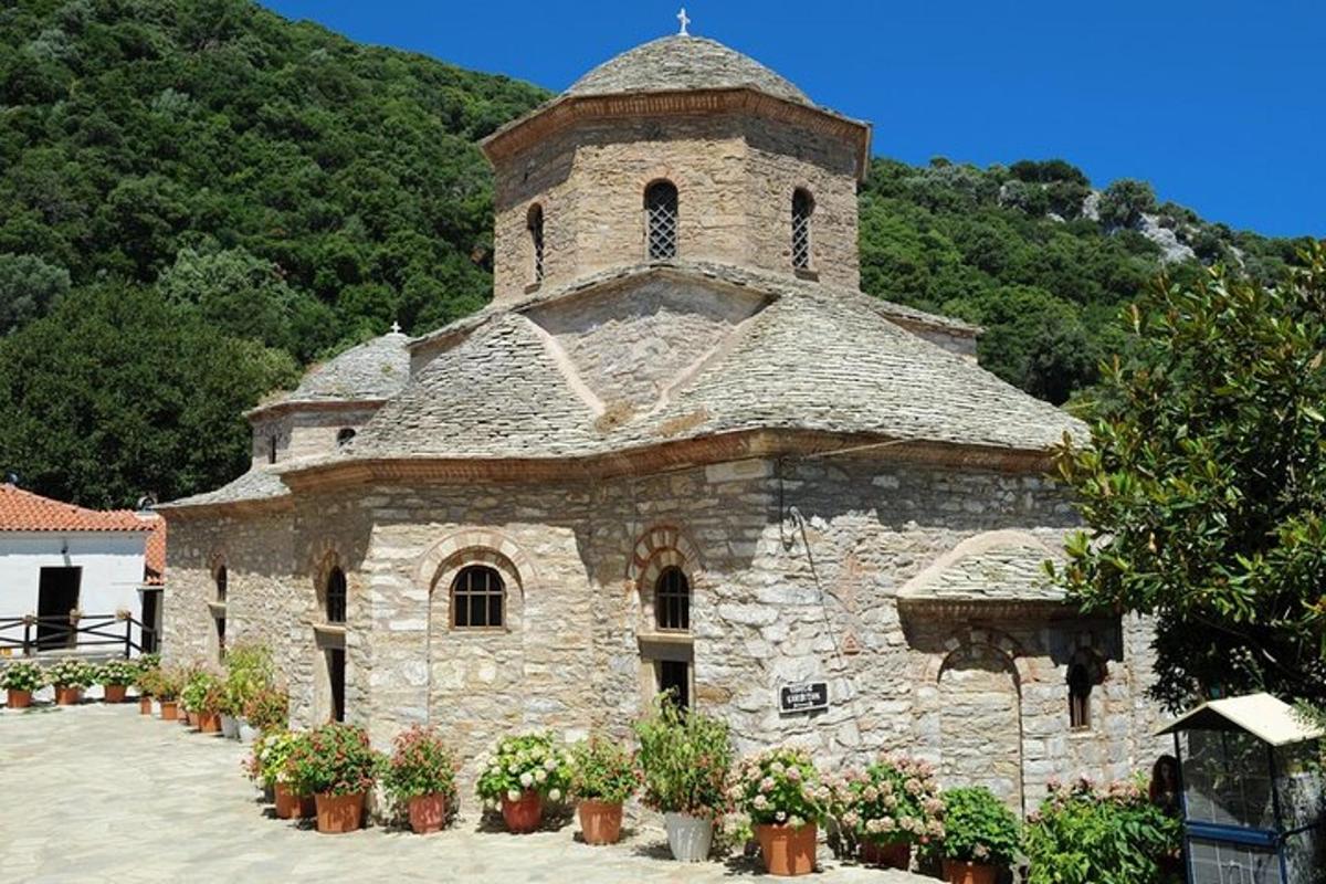 an old stone church with flowers in front of it
