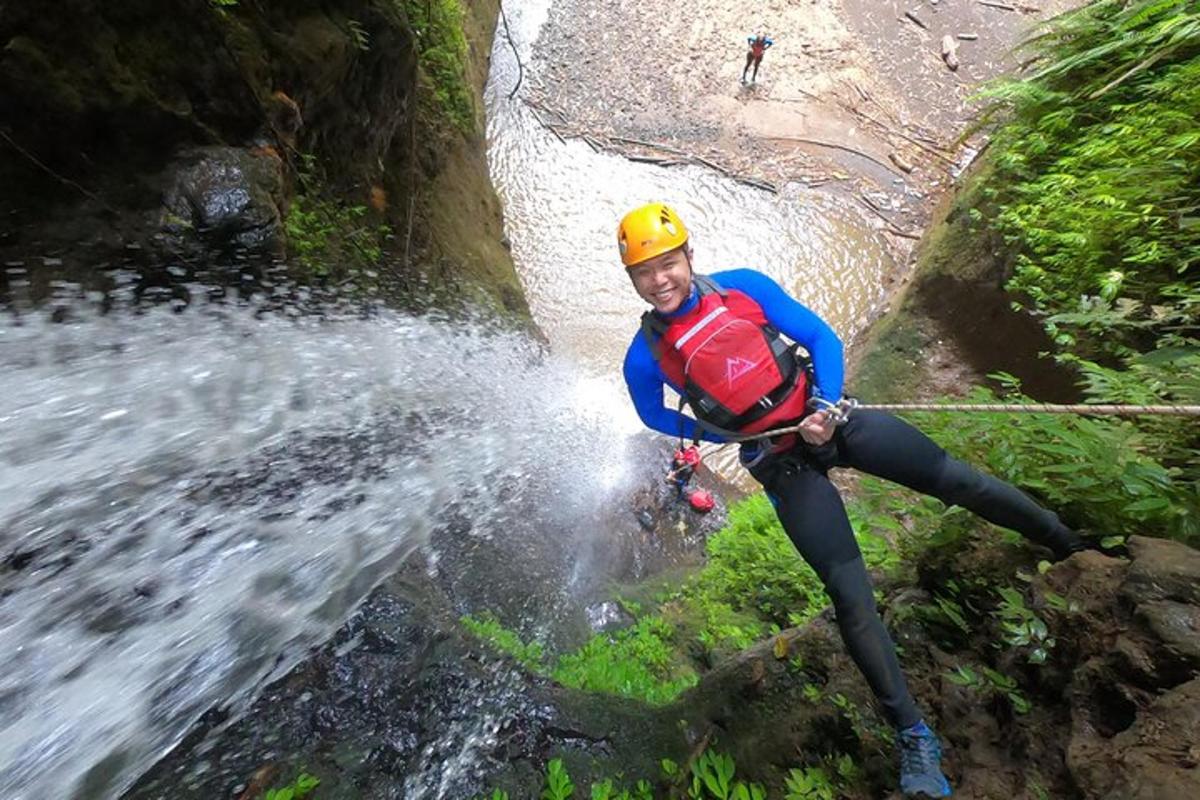a man in a yellow helmet crossing a river