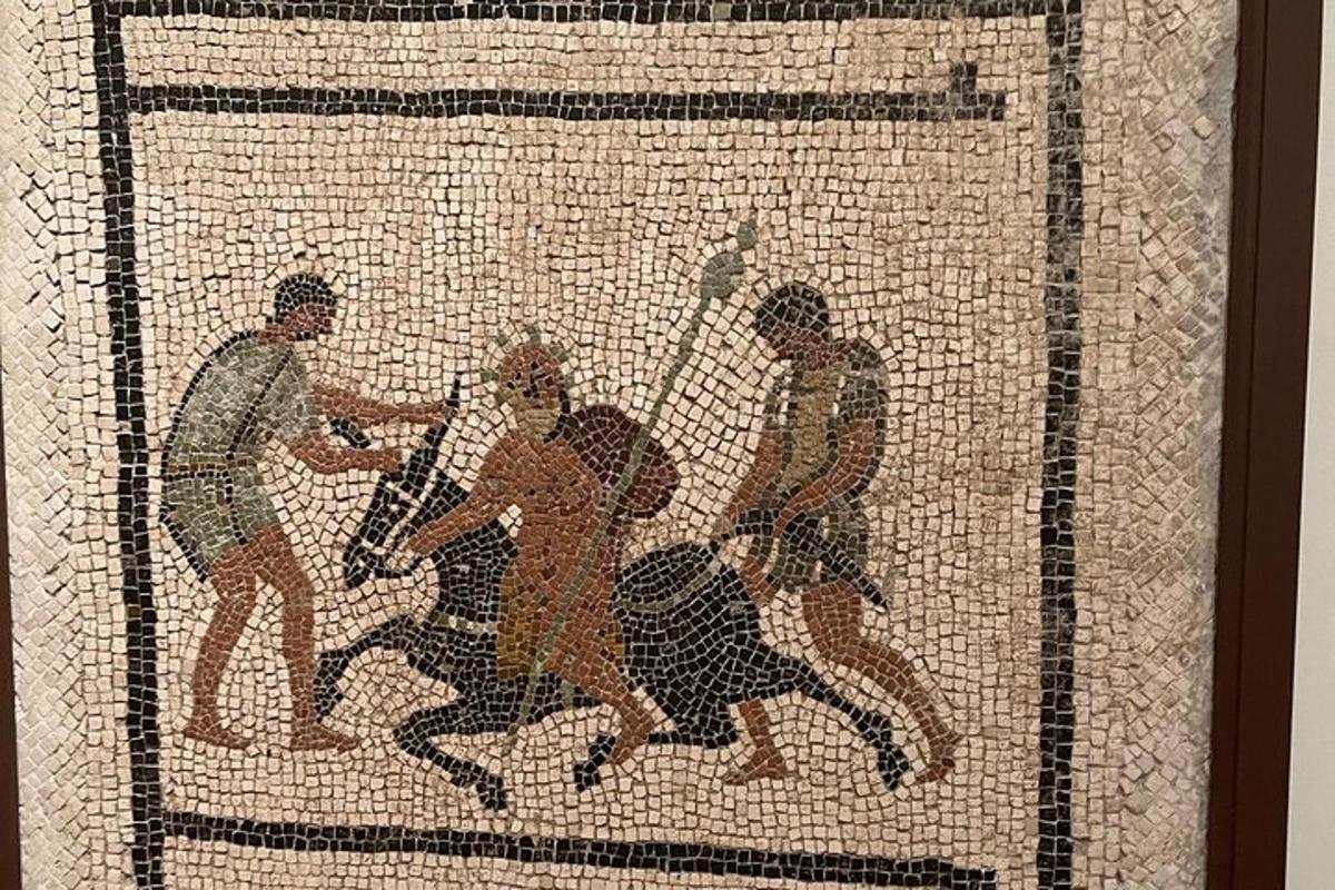 un mosaico di un uomo che impugna una lancia durante un combattimento