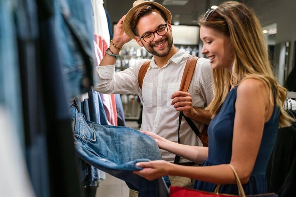 um homem e uma mulher olhando jeans em uma loja