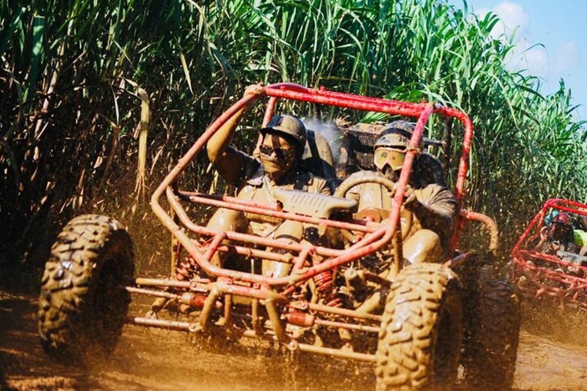 two people in an off road vehicle in the mud