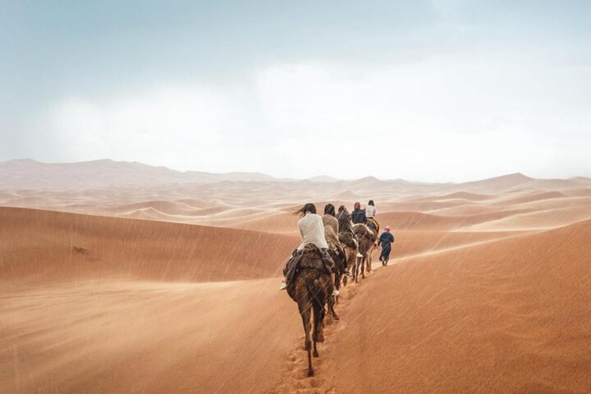 a group of people riding horses in the desert