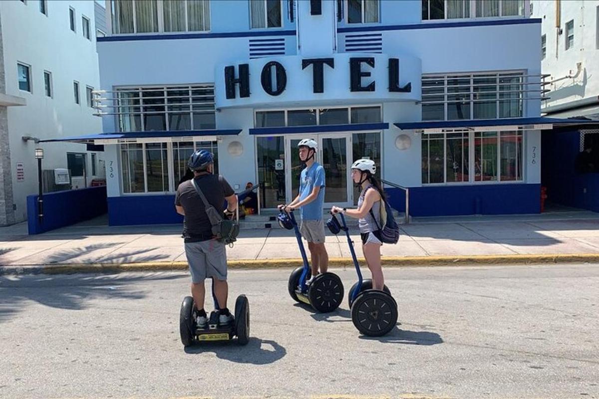 Skupina lidí jezdících na segwayích před hotelem