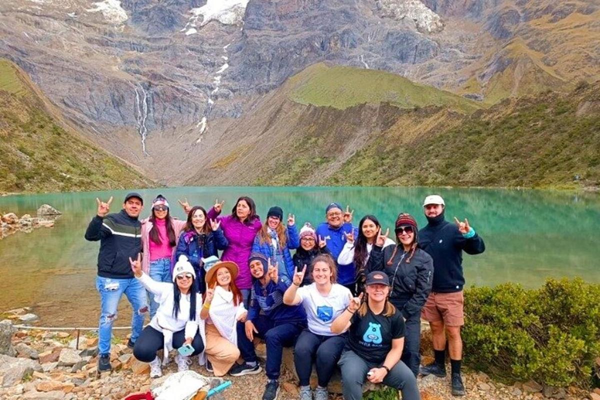 um grupo de pessoas posando em frente a um lago