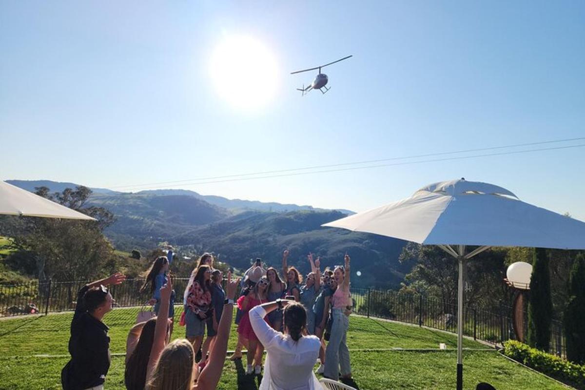 a group of people standing in a field with a helicopter