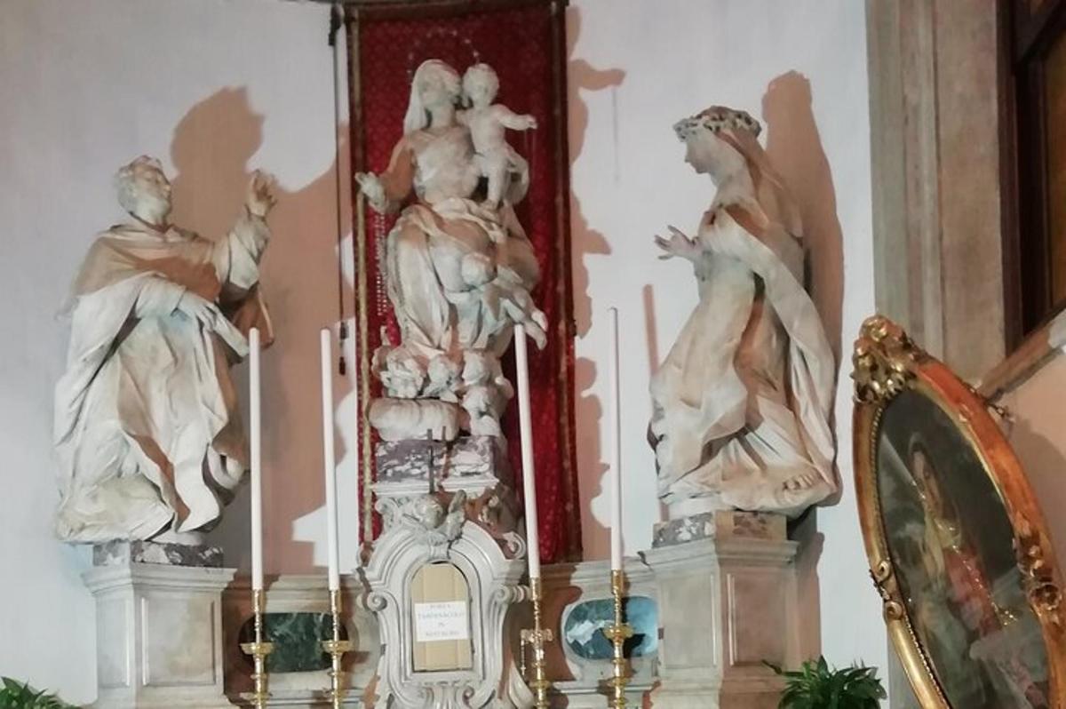 un grup d'estàtues assentades a la part superior d'una paret