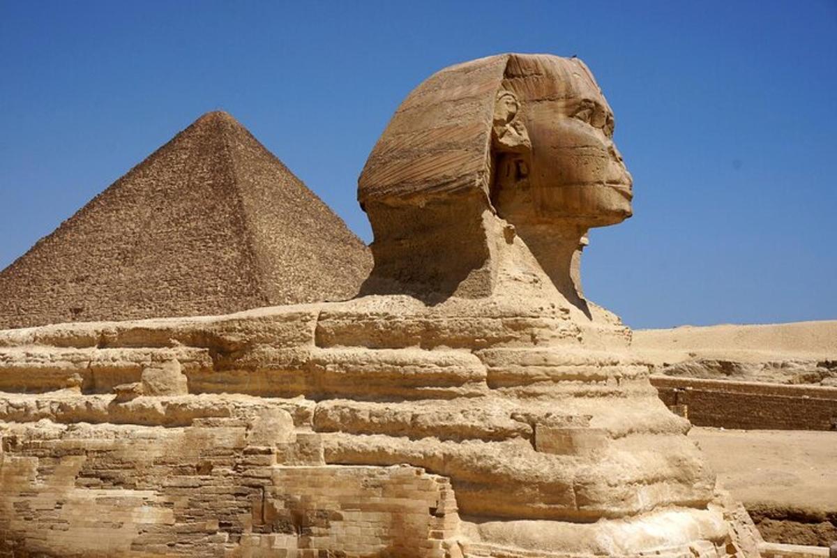 socha před sfingou a pyramidou