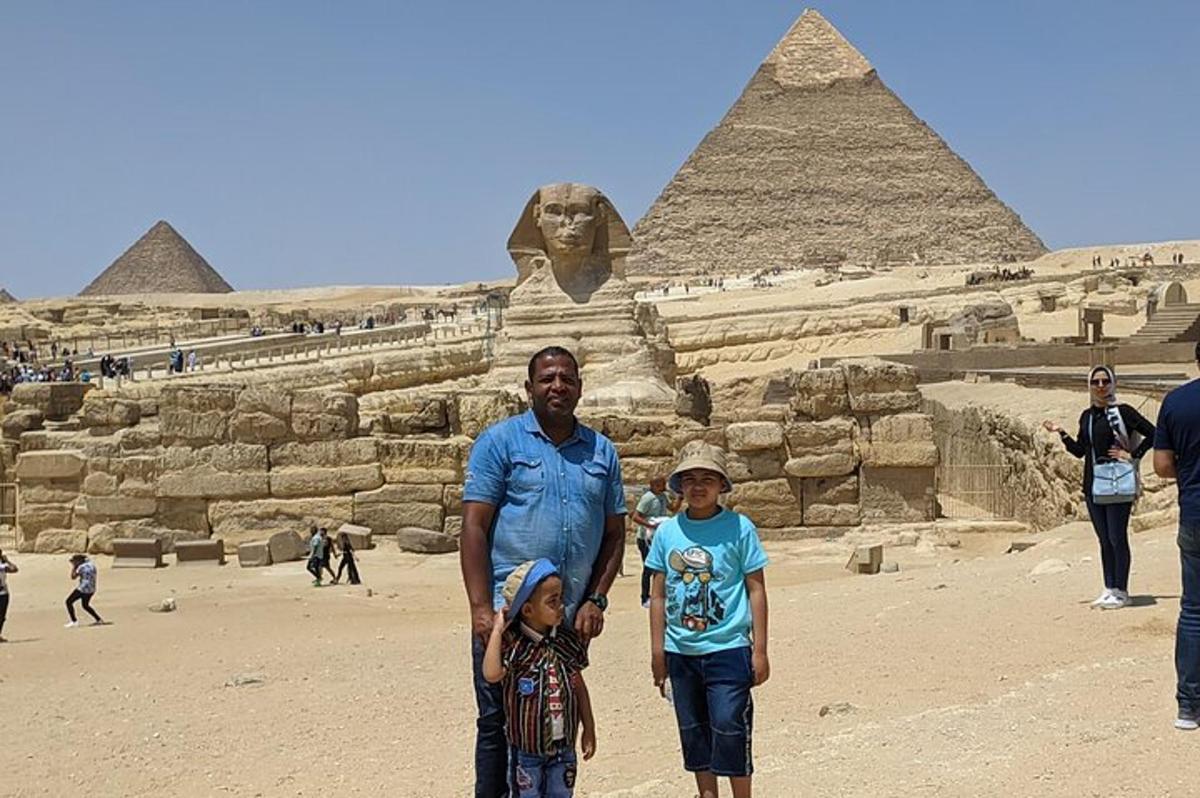 muž a dvě děti stojící před pyramidami