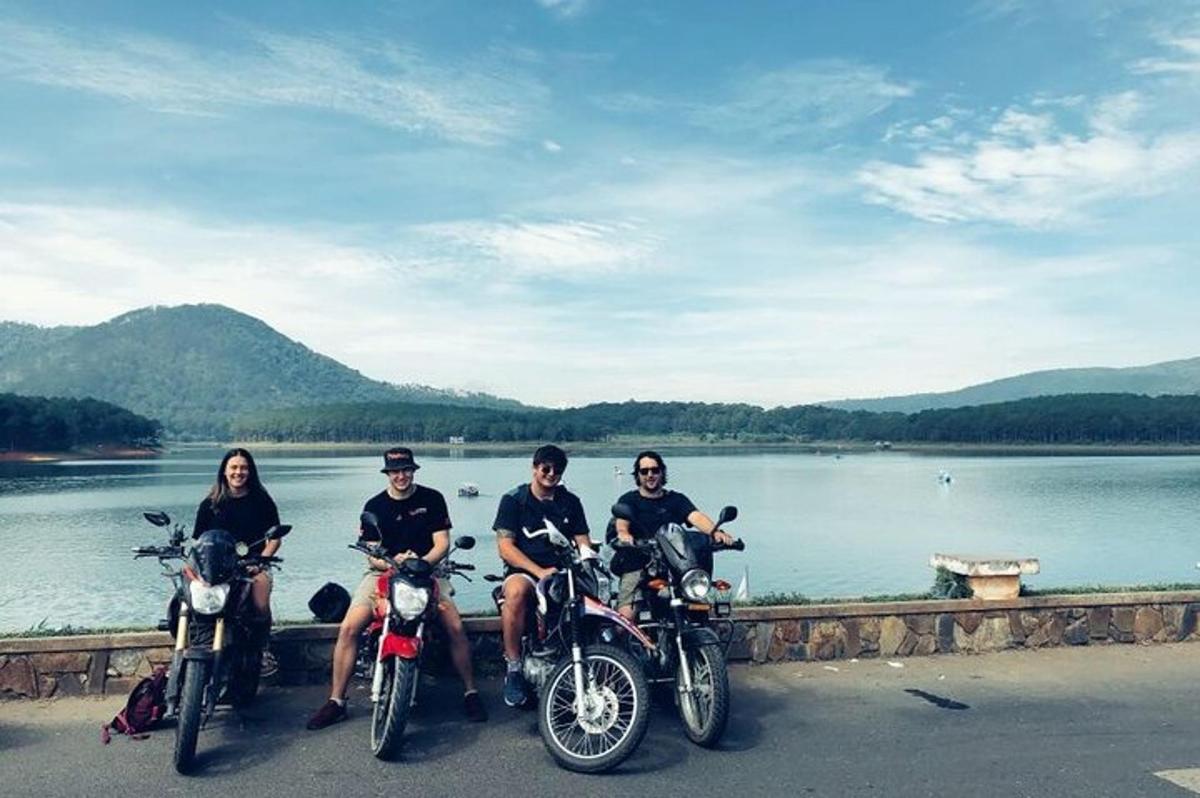 un gruppo di persone sedute su motociclette accanto a un lago