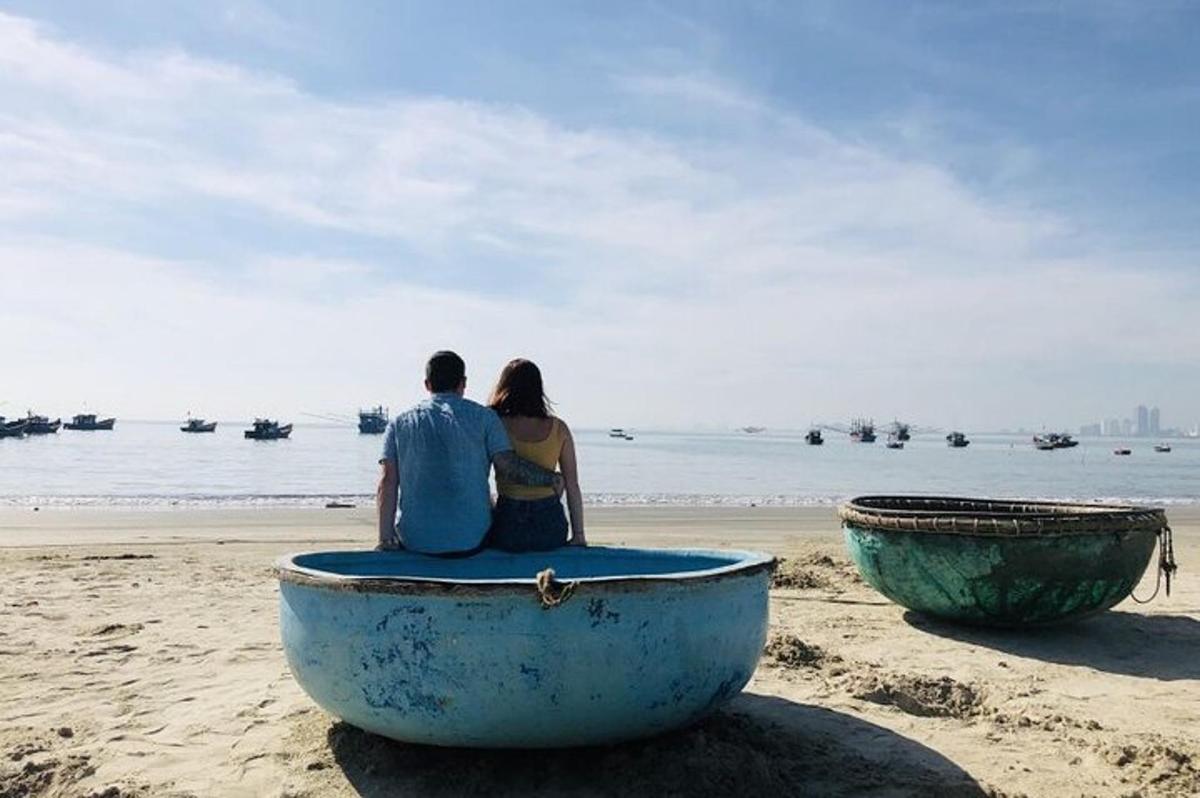 una coppia seduta su una barca sulla spiaggia