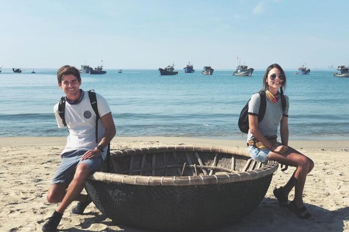 un uomo e una donna seduti su una barca sulla spiaggia