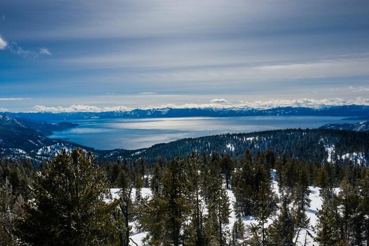 a view of a lake in the mountains with snow