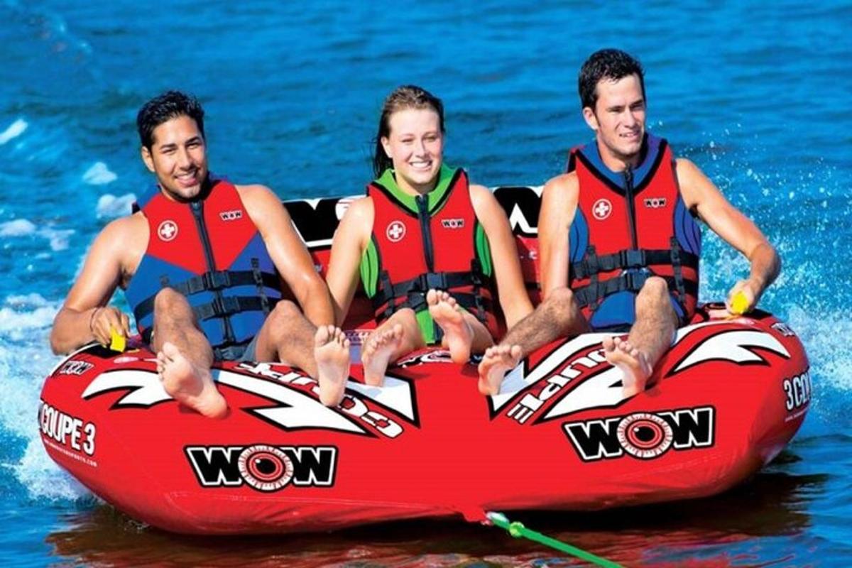 drei Männer in Schwimmwesten sitzen auf einem Floß im Wasser