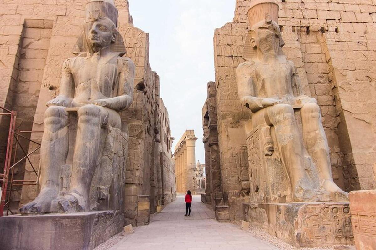 cilvēks, kas iet ēkas statuju priekšā