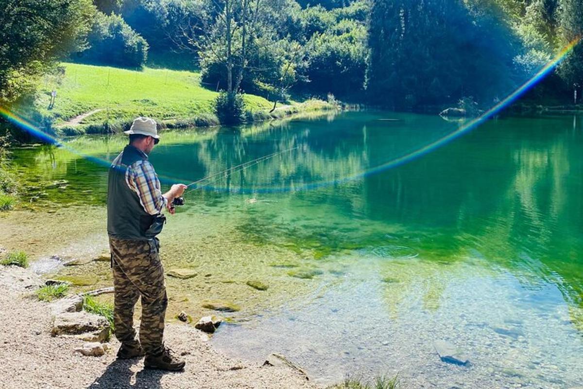 seorang lelaki berdiri di sebelah tasik memancing