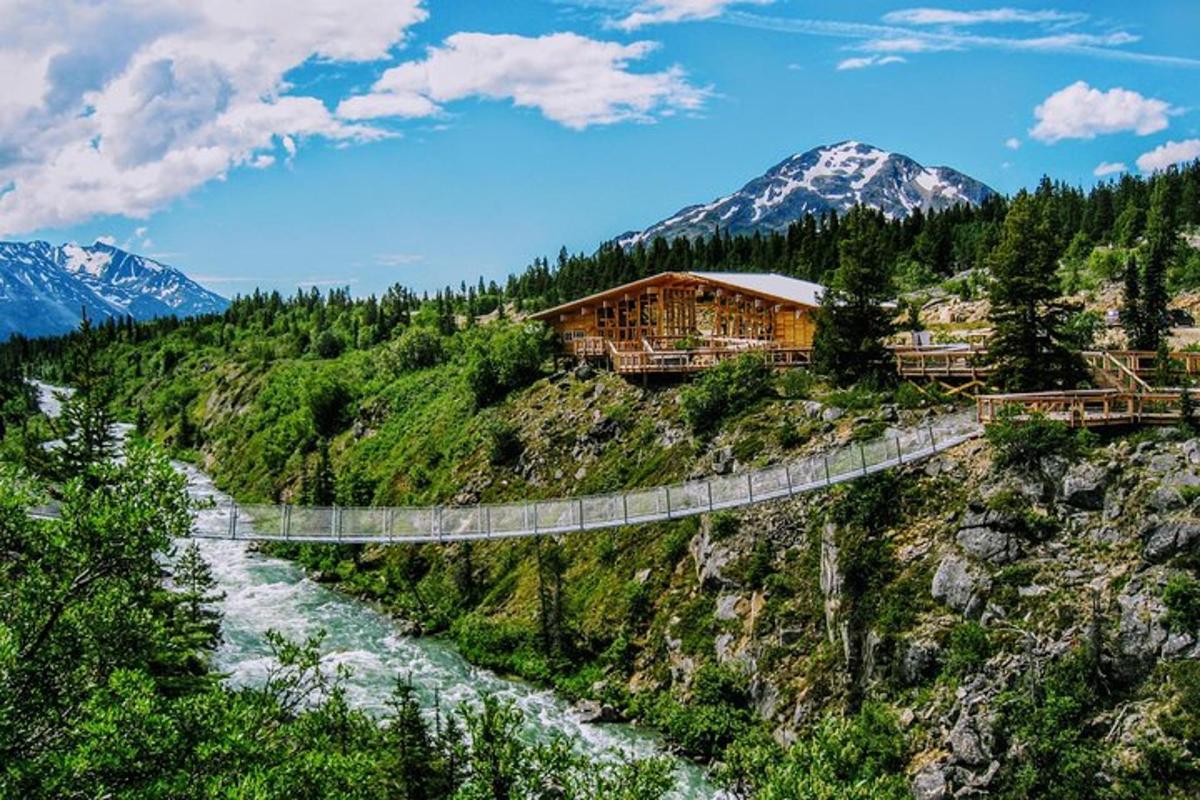 a bridge over a river with mountains in the background