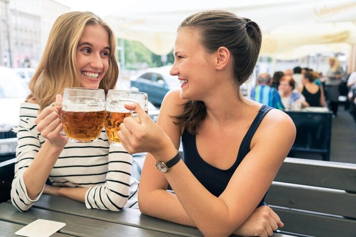 two women sitting at a table drinking beer