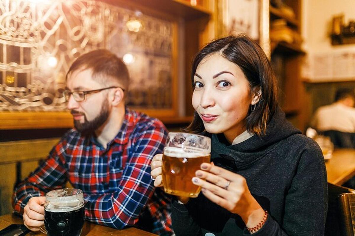 two people sitting at a table drinking beer