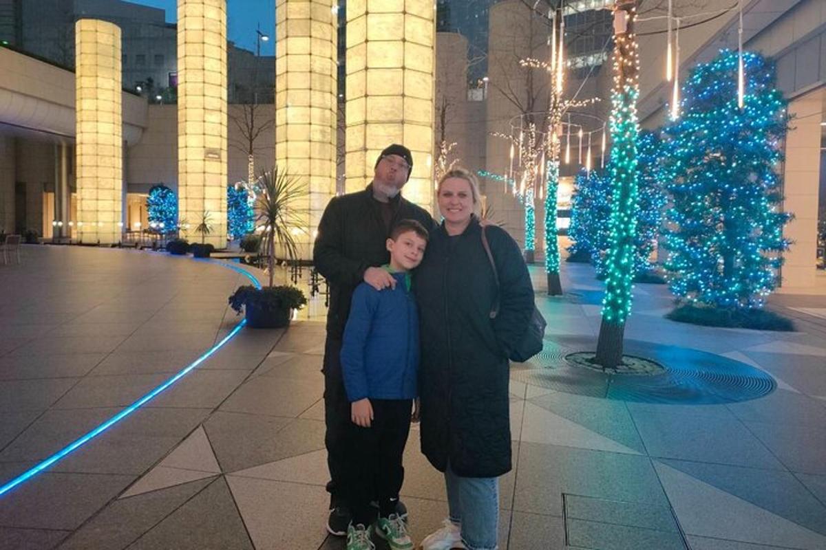 en familie som står foran en bygning med julelys
