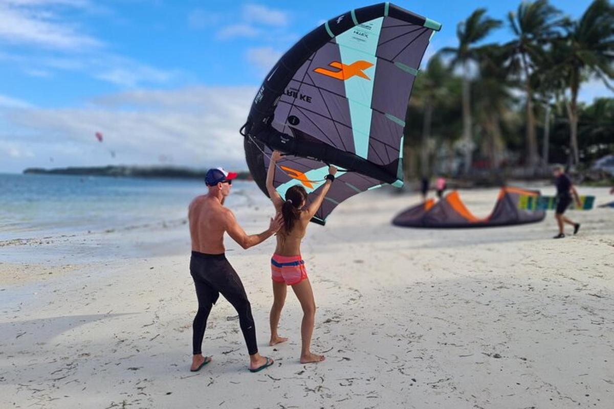 a man and a girl on the beach with a kite