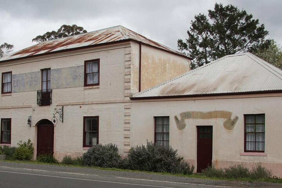 an old white building on the side of the road
