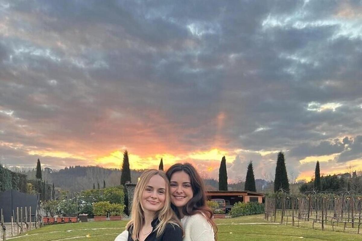 due donne posano per una foto davanti a un tramonto