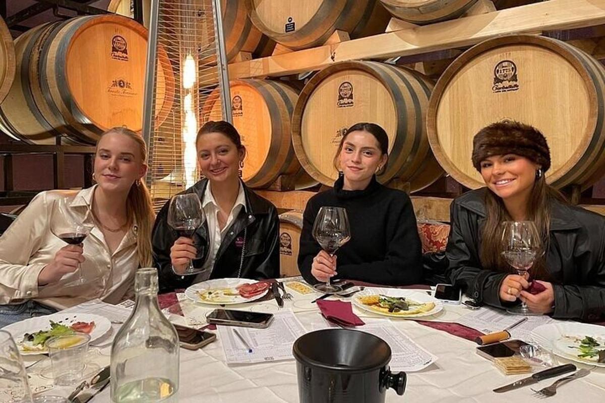 un gruppo di donne sedute a un tavolo con bicchieri di vino