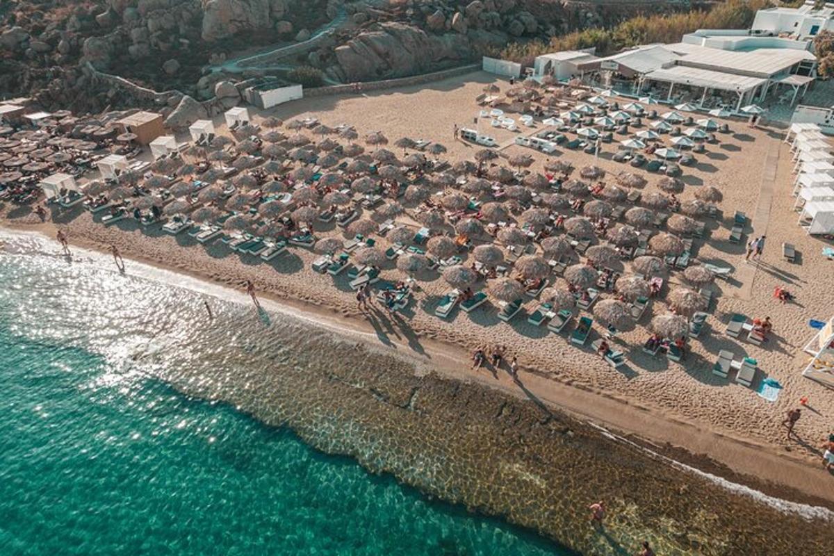 an aerial view of a beach with chairs and umbrellas