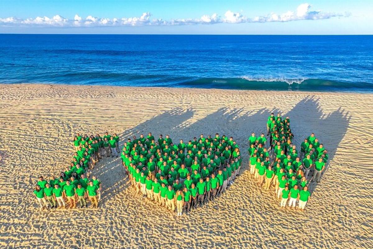 grupa ljudi koja tvori srce na plaži