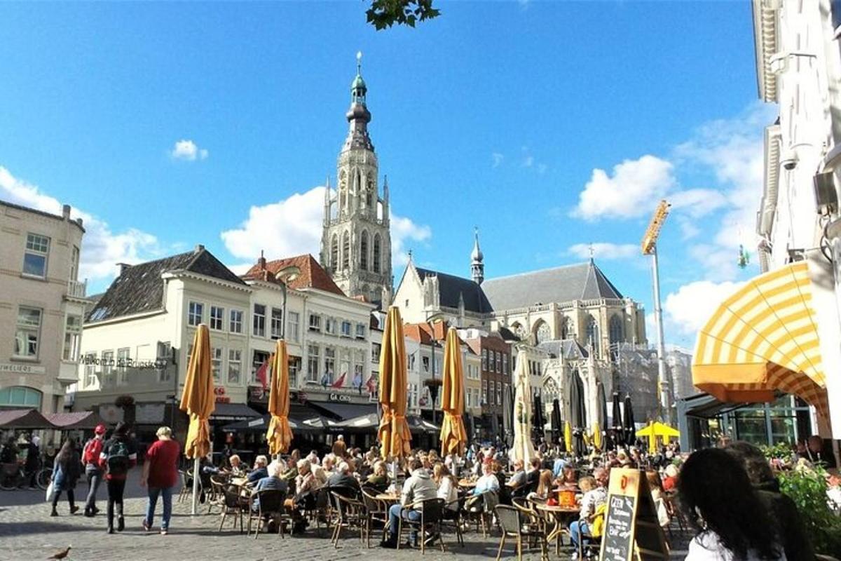 tłum ludzi siedzących przy stołach w mieście