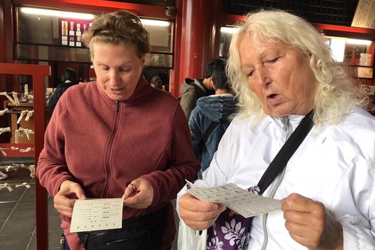 Dos mujeres mayores de pie en una tienda mirando papeles