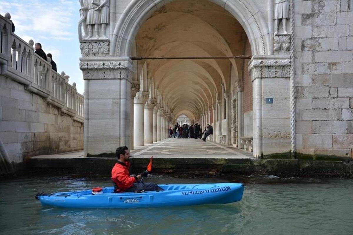 un home en un caiac a l'aigua sota un pont