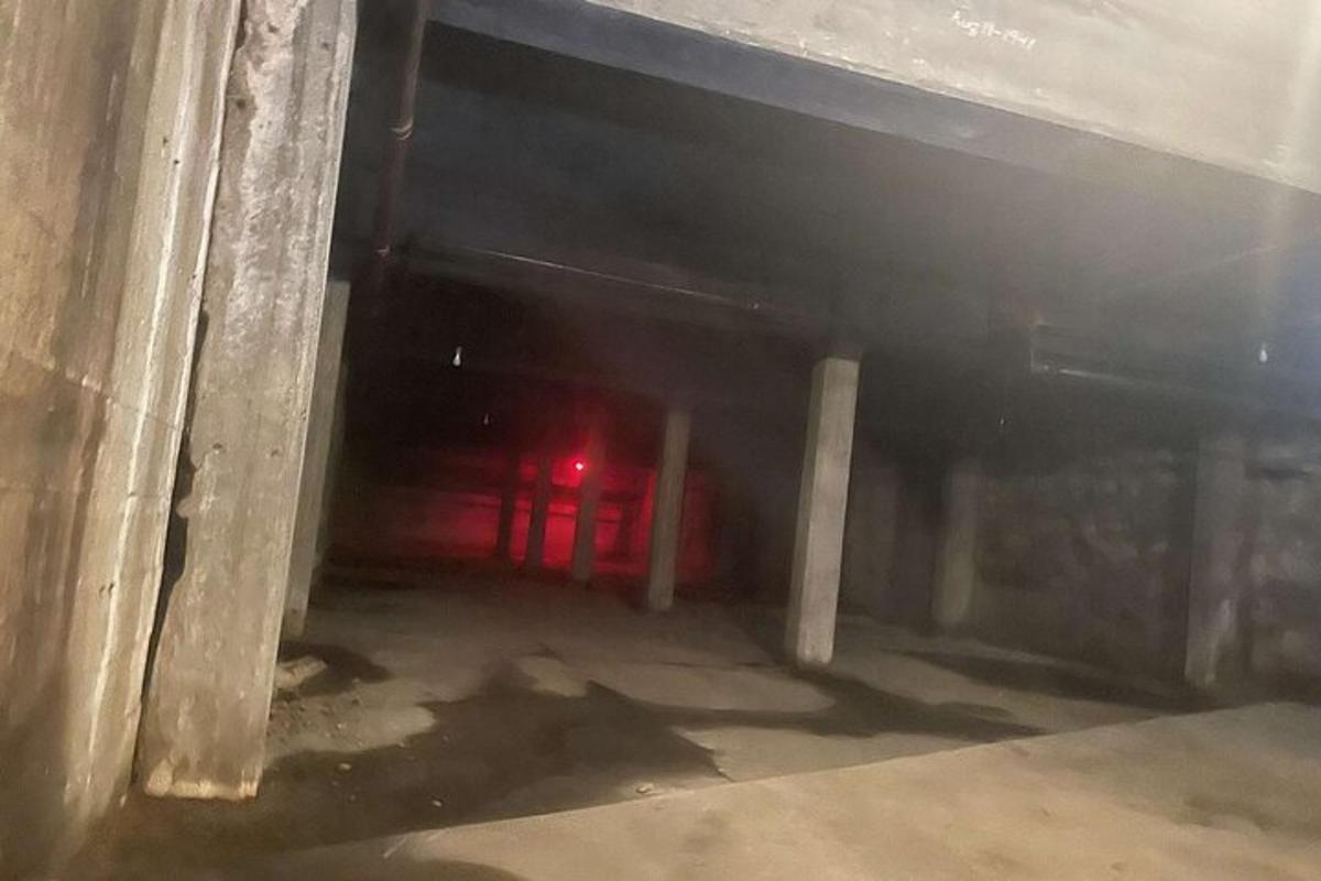 um túnel escuro com uma luz vermelha ao fundo