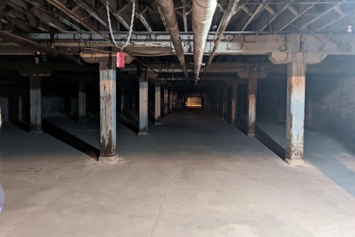 an empty building with concrete pillars and a tunnel