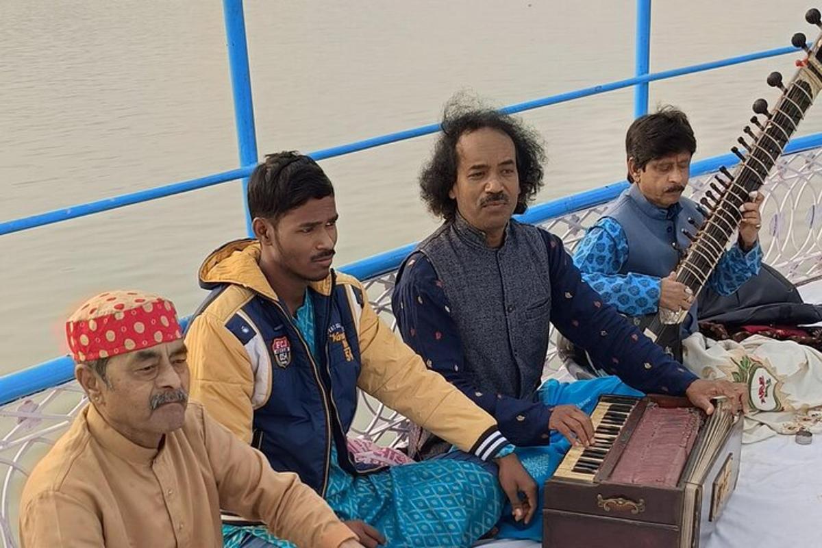 sekelompok pria duduk di atas perahu dengan gitar
