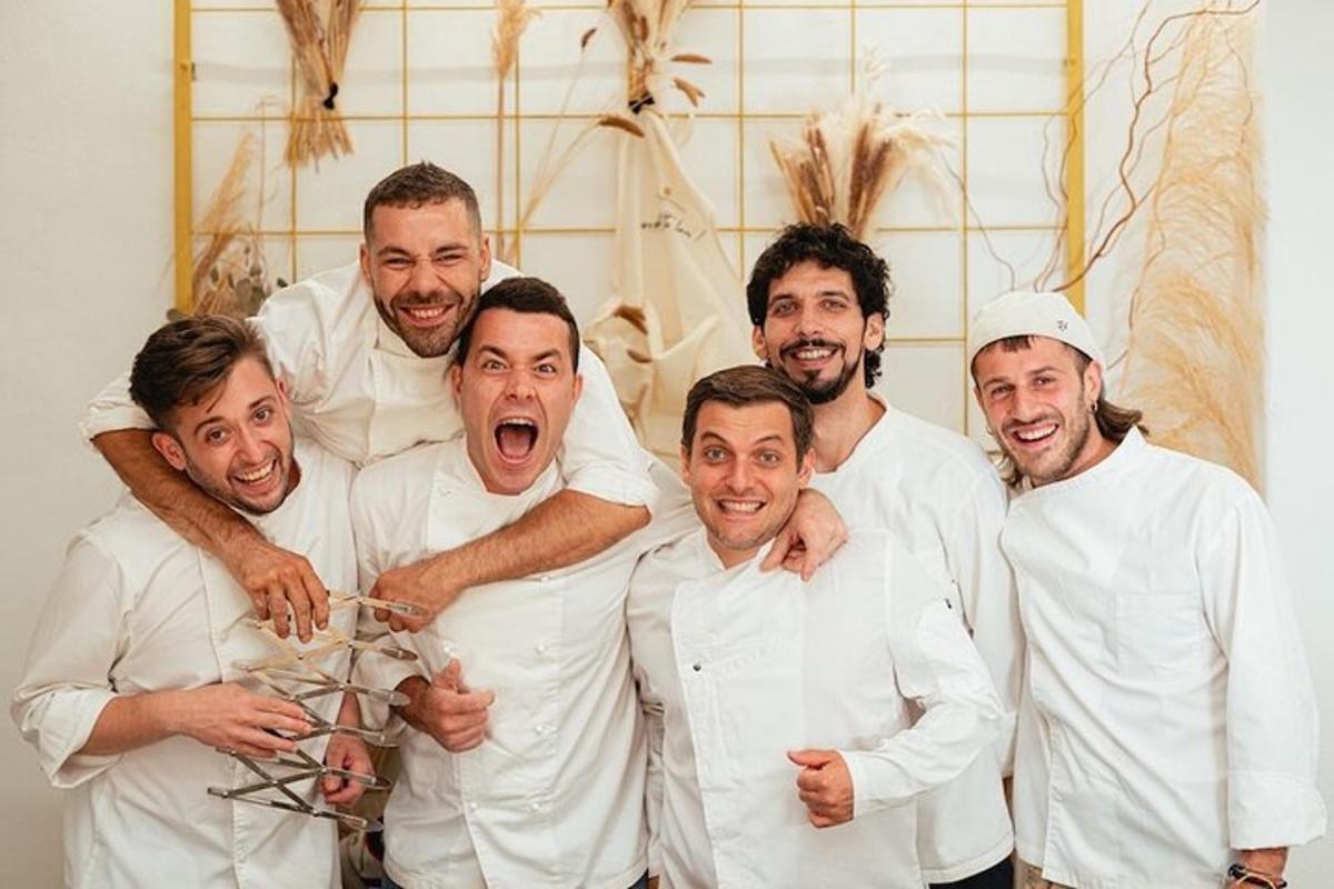 skupina mužů v bílých uniformách pózujících pro fotografii
