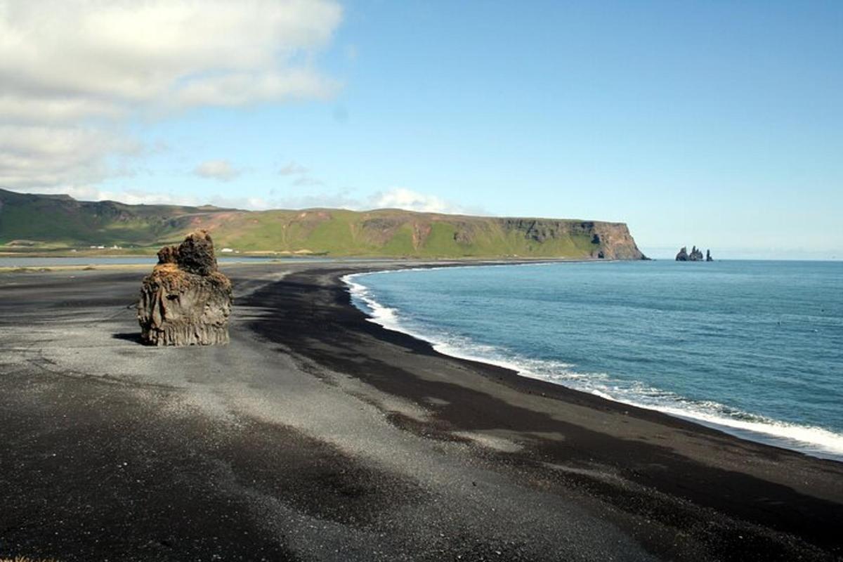 un castello di sabbia su una spiaggia nera vicino all'oceano