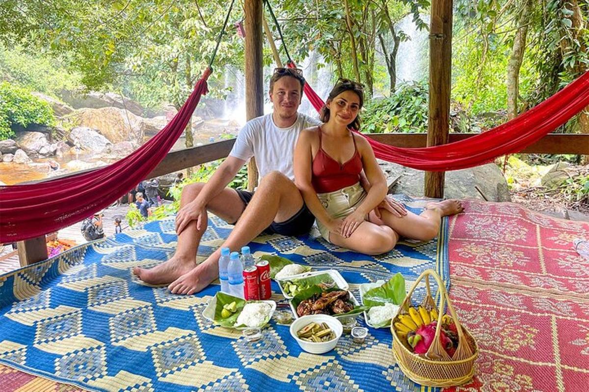 seorang pria dan wanita duduk di tempat tidur gantung dengan makanan